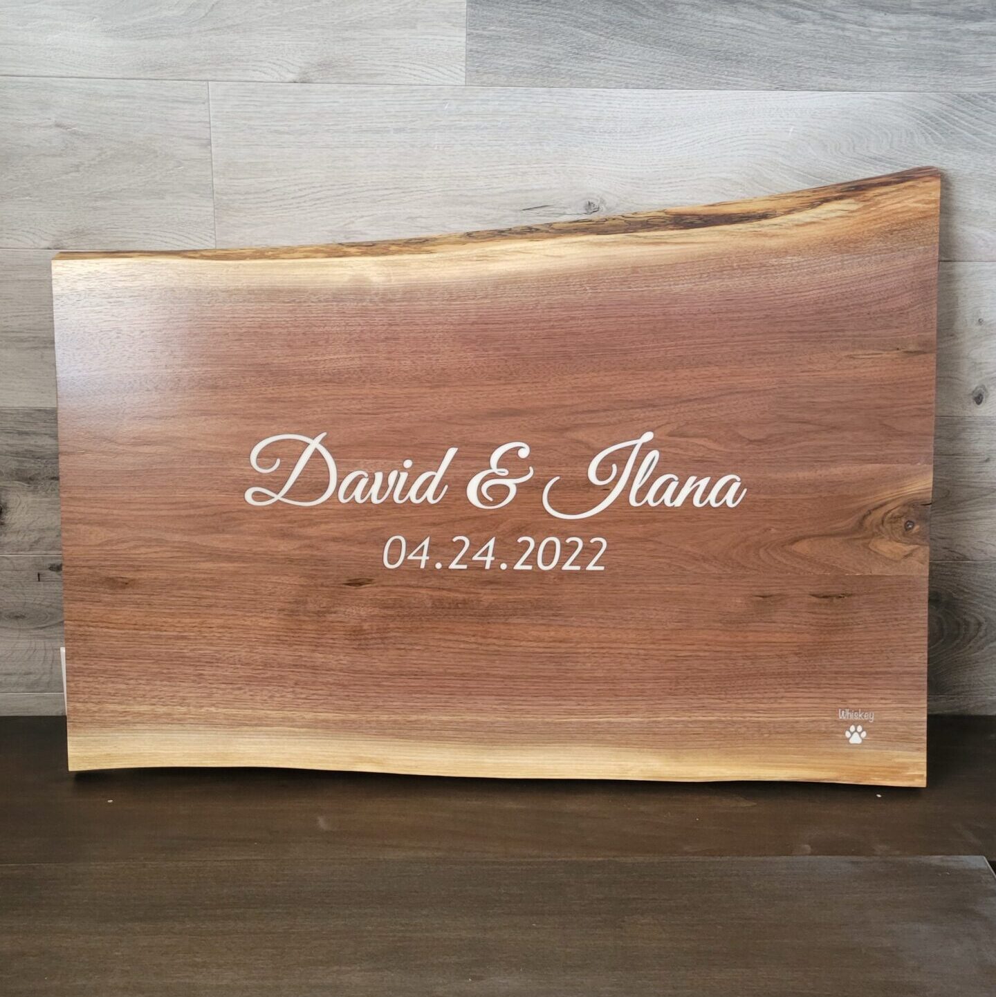 A walnut slab with white epoxied names engraved into the surface